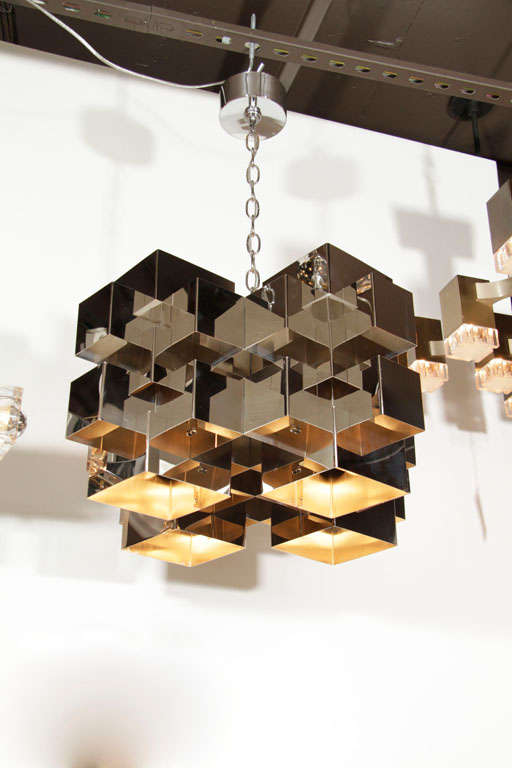 Nickel finish chandelier composed of multiple interlocking cube elements arranged in five tiers.  Bears four Edison-base ceramic sockets.